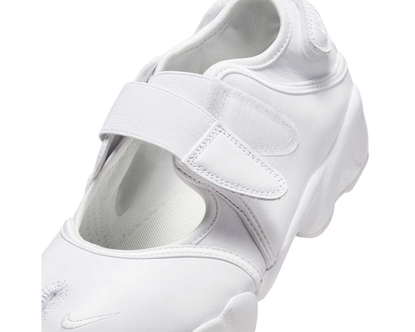 Scarpa sportiva da donna in tessuto bianco con design aperto.