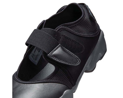 Scarpa sportiva da donna con design aperto e colore grigio scuro.